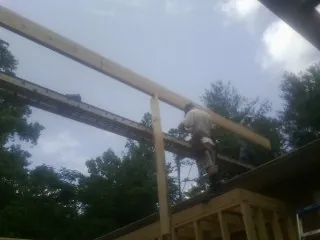 Carpenter setting a ridge beam over a new addition frame — Ice Dam Removal by Roofing Brothers in Limekiln
