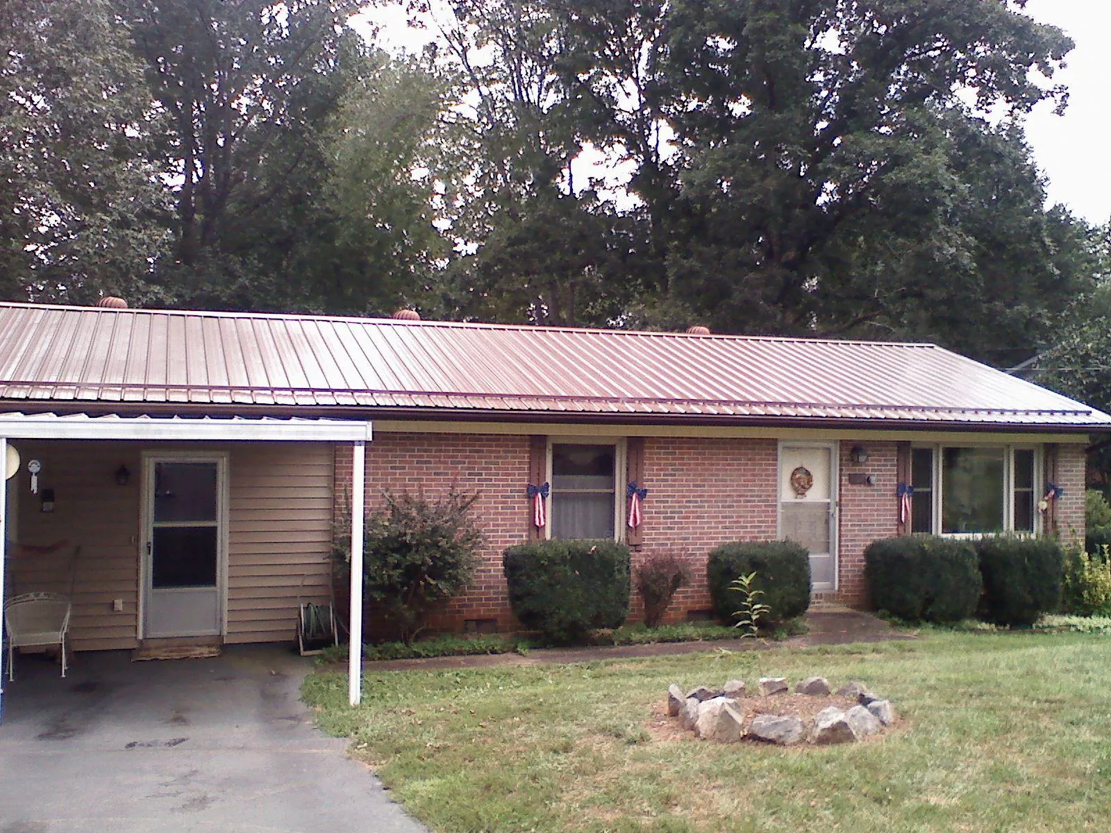 Bronze metal roof and carport on a brick ranch home — Roof Repair work by our crew in Limekiln